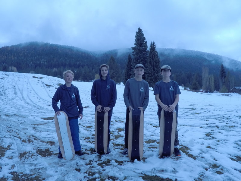 Quatre jeunes avec leurs SlopeDeck sur une pente locale